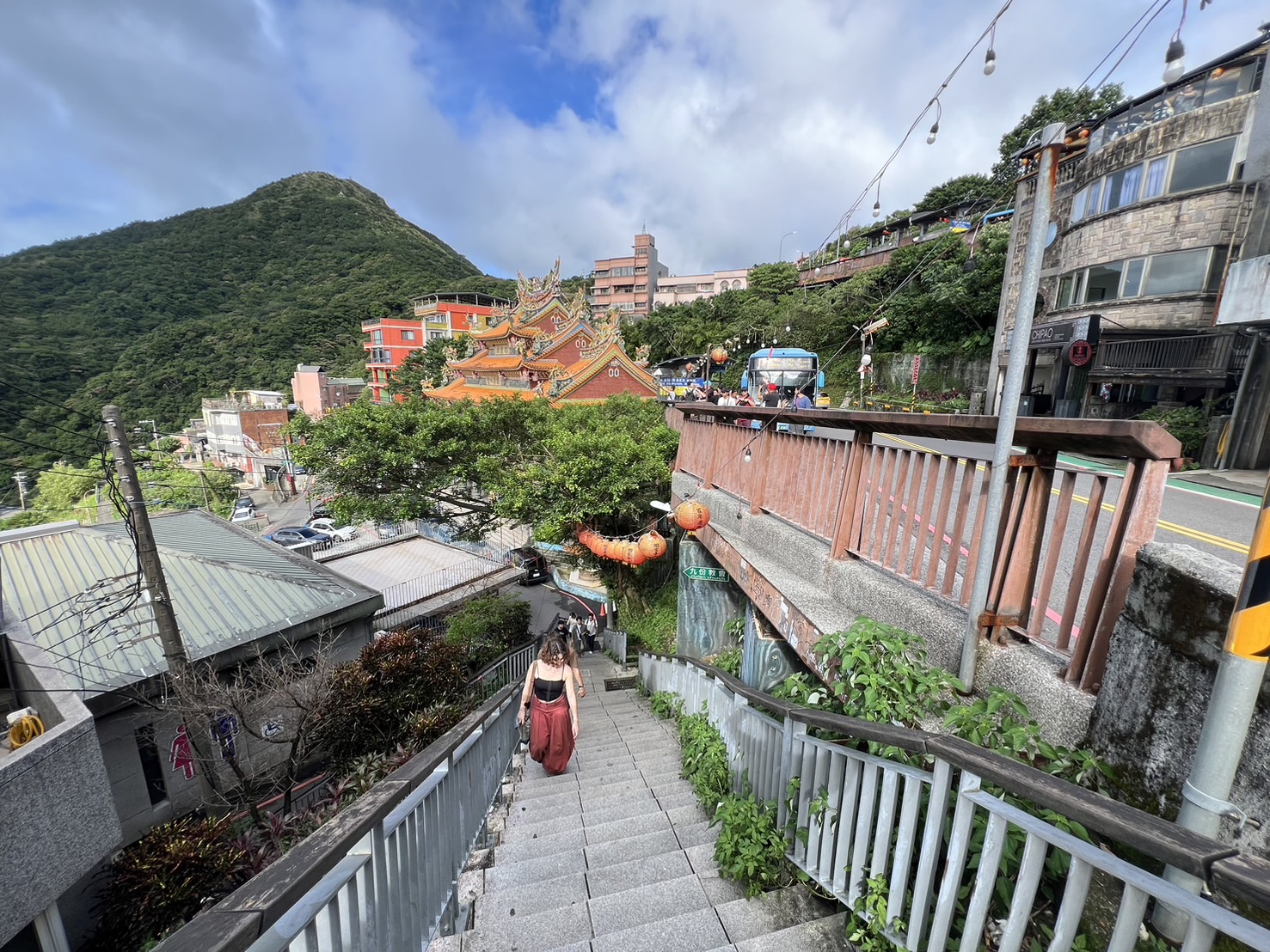 九份山嶼海民宿至九份老街的階梯路段，遊客正在拾階而上，背景可見九份山城的壯麗景色